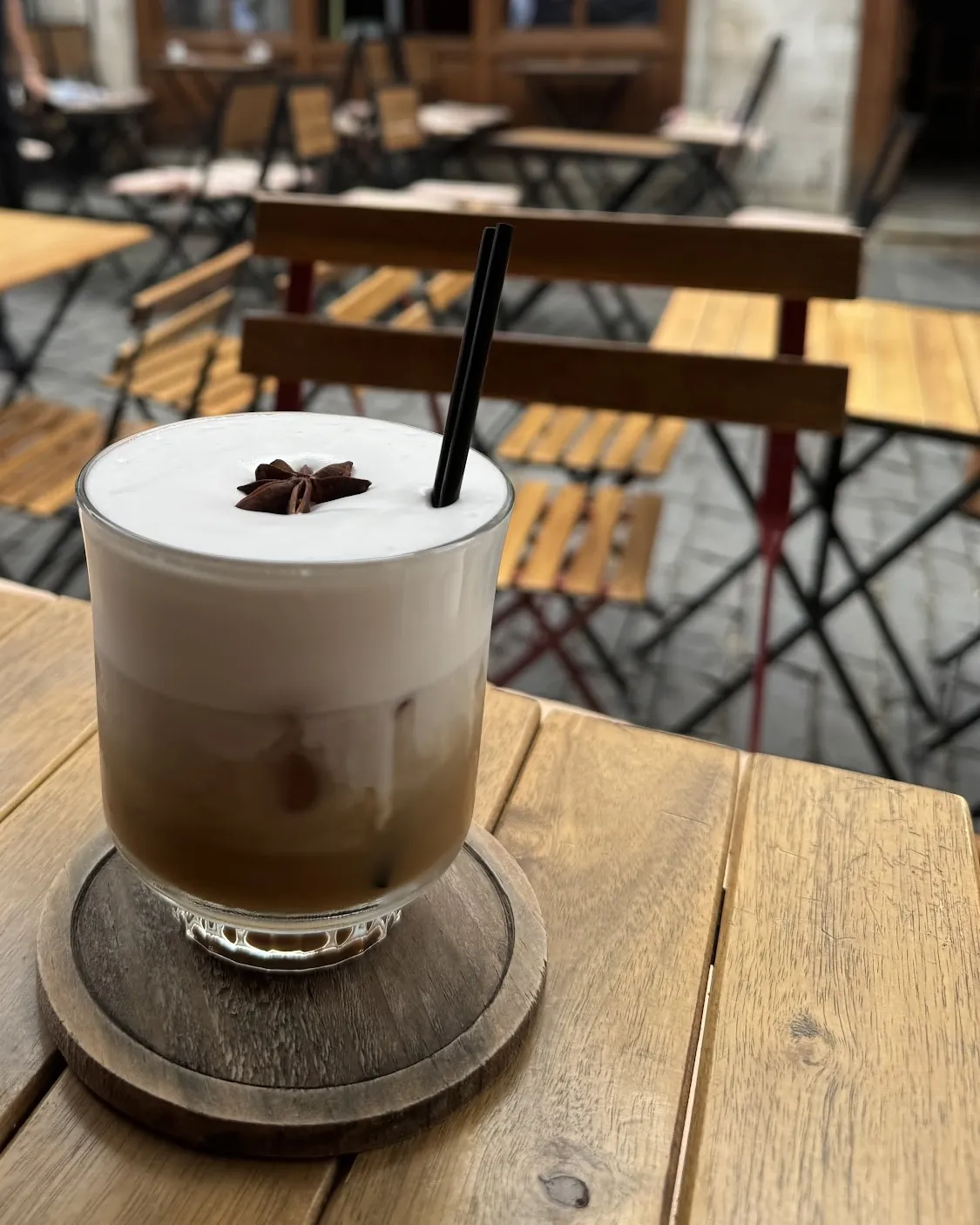 An Irish coffee on a wooden table on the cobbled terrace of the old bazaar