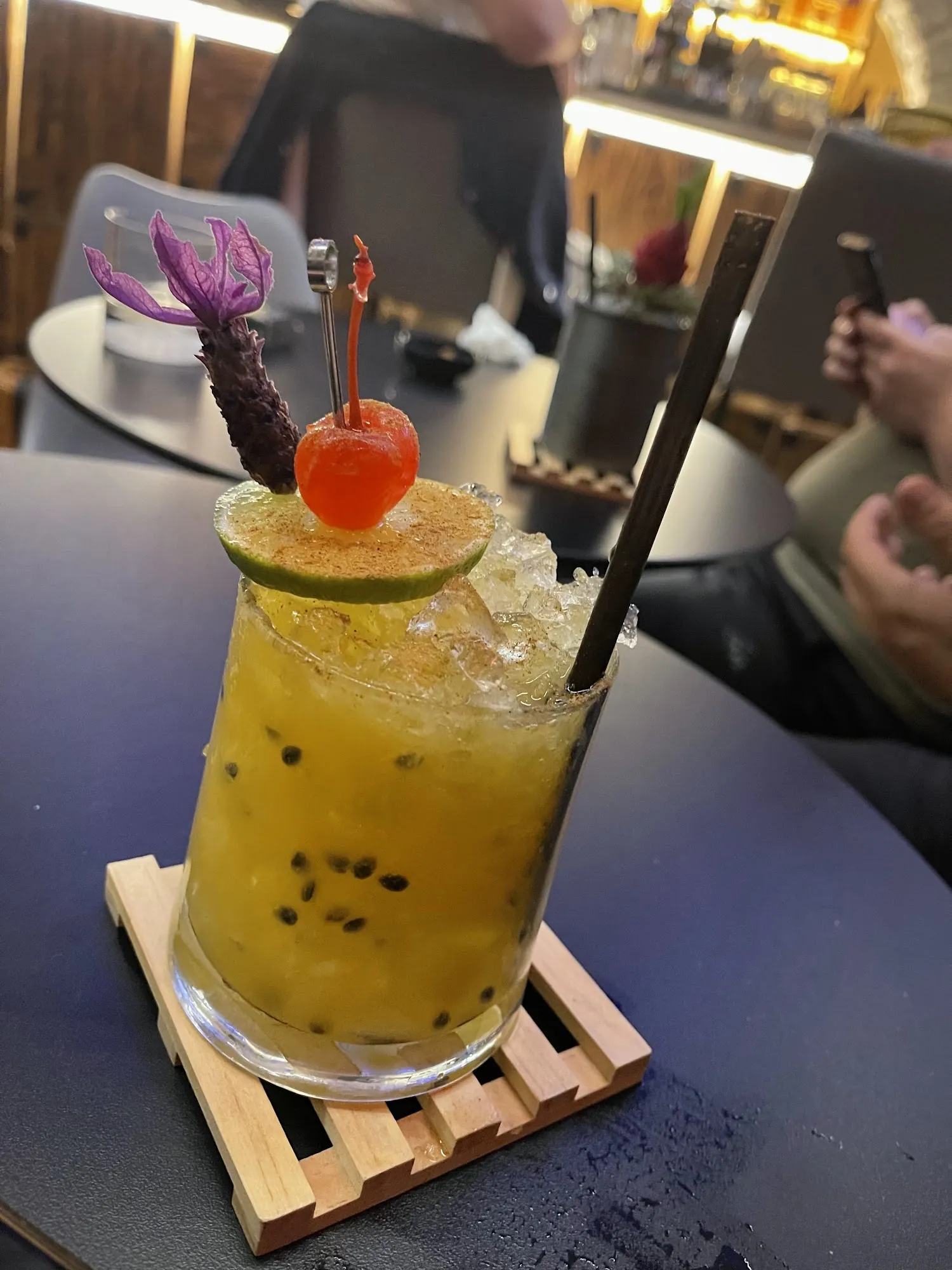 A Hangover signature cocktail with passion fruit, a cherry and a flower garnish